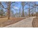Well-maintained gray home with a newly paved driveway and mature trees at 7999 Englewood Rd, Indianapolis, IN 46240