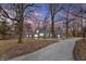 Home with a circular driveway framed by mature trees and new landscaping at 7999 Englewood Rd, Indianapolis, IN 46240