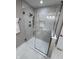 Modern shower featuring neutral tile, glass doors and a built-in niche for toiletries at 7999 Englewood Rd, Indianapolis, IN 46240