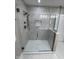 Modern shower featuring neutral tile, glass doors and a built-in niche for toiletries at 7999 Englewood Rd, Indianapolis, IN 46240