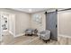 Comfortable sitting area with two chairs, side table, artwork, and a stylish sliding barn door at 7999 Englewood Rd, Indianapolis, IN 46240