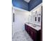 Bathroom featuring double sink vanity, blue accent wall, and decorative lighting at 8150 Foxchase Cir, Indianapolis, IN 46256