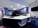 Open kitchen with bar seating, granite counters, stainless appliances, and stylish blue cabinets at 8150 Foxchase Cir, Indianapolis, IN 46256