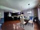 Cozy dining area featuring hardwood floors, modern chandelier and bar seating in kitchen at 8150 Foxchase Cir, Indianapolis, IN 46256
