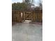 Backyard area featuring a cracked concrete patio, a wooden fence, and foliage behind the fence at 8501 Canterbury E Sq, Indianapolis, IN 46260