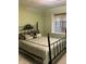 Bedroom with decorative iron bed frame, plush pillows, and natural light from the window at 8501 Canterbury E Sq, Indianapolis, IN 46260