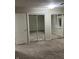 Spacious bedroom featuring full mirrored closet doors and beige carpet at 8501 Canterbury E Sq, Indianapolis, IN 46260
