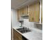 Clean kitchen featuring marble countertops and wood cabinets with a double sink at 8501 Canterbury E Sq, Indianapolis, IN 46260