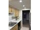 Galley kitchen featuring marble countertops, stainless steel sink, and wooden cabinets at 8501 Canterbury E Sq, Indianapolis, IN 46260