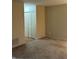 Well-lit living room featuring a large closet with bifold doors and tan carpet at 8501 Canterbury E Sq, Indianapolis, IN 46260