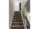 Carpeted staircase with white walls and black railing in a residential home at 8501 Canterbury E Sq, Indianapolis, IN 46260