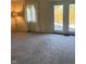 A carpeted living room offers bright natural light with a view of the fenced backyard through double doors at 8501 Canterbury E Sq, Indianapolis, IN 46260