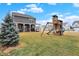 A backyard with playset and covered wood porch offers outdoor fun and relaxation at 9063 Moyer Pl, Pendleton, IN 46064