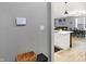 Open-concept living space featuring modern gray walls, a view into the kitchen and dining area, and ample light at 9063 Moyer Pl, Pendleton, IN 46064