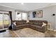 Cozy living room with a gray sectional sofa, patterned rug, and sliding glass doors leading to the deck at 9063 Moyer Pl, Pendleton, IN 46064