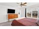 Bright main bedroom with a ceiling fan, TV, dresser, and window with blinds at 9063 Moyer Pl, Pendleton, IN 46064