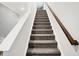 Staircase featuring carpeted steps, a wooden handrail, and white walls at 9063 Moyer Pl, Pendleton, IN 46064