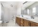 Bathroom featuring a double sink vanity with oak cabinets, mirror and a shower with glass door at 9239 Stones Ferry Way, Indianapolis, IN 46278