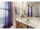 Bright bathroom featuring a single vanity, mirror, and window with purple curtains at 9239 Stones Ferry Way, Indianapolis, IN 46278