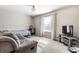 This bedroom features neutral walls, carpet flooring, a window and a comfortable couch at 9239 Stones Ferry Way, Indianapolis, IN 46278