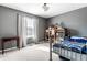 Comfortable bedroom with a large window, neutral carpet, and dark gray walls at 9239 Stones Ferry Way, Indianapolis, IN 46278