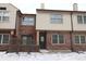 Charming townhouse featuring brick and neutral siding, complemented by snow-covered landscaping at 9523 Maple Way, Indianapolis, IN 46268