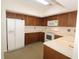 Well-equipped kitchen featuring wood cabinetry, white appliances, and ample counter space at 9523 Maple Way, Indianapolis, IN 46268
