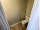 Compact powder room featuring wood flooring, and neutral walls, equipped with a standard toilet at 9634 Beckett St, Avon, IN 46123