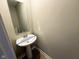 Small bathroom with a pedestal sink, mirror, and a toilet with a wood-look floor at 9634 Beckett St, Avon, IN 46123