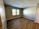 A well-lit bedroom with wood flooring, neutral walls, and two windows providing ample natural light at 9634 Beckett St, Avon, IN 46123