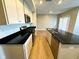 Close-up kitchen view featuring stainless steel appliances, white cabinetry, and a center island with black countertops at 9634 Beckett St, Avon, IN 46123