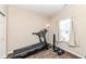 This bedroom includes an exercise machine with a window for natural light, creating a fitness-friendly space at 1058 W Limestone Way, Fortville, IN 46040