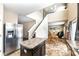 Open-concept kitchen featuring dark cabinets, a kitchen island, and views into the dining and living areas at 1058 W Limestone Way, Fortville, IN 46040