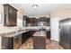 Modern kitchen with dark cabinetry, stainless steel appliances, an island, and ample counter space at 1058 W Limestone Way, Fortville, IN 46040