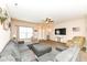 Relaxing living room with an expansive sectional sofa, large TV, and a ceiling fan for comfortable living at 1058 W Limestone Way, Fortville, IN 46040