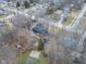 An aerial shot displays a home with a large backyard, a shed, a small sports court, and surrounded by trees at 11035 W Lakeshore Dr, Carmel, IN 46033