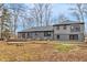 Spacious backyard featuring mature trees and rear view of house with screened-in patio at 11035 W Lakeshore Dr, Carmel, IN 46033