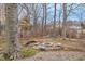 A backyard fire pit with stone seating surrounded by trees offers a cozy outdoor gathering spot at 11035 W Lakeshore Dr, Carmel, IN 46033