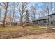 Large backyard with mature trees, landscaping, and the rear of the home at 11035 W Lakeshore Dr, Carmel, IN 46033