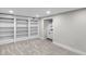Finished basement with neutral carpet and sliding bookshelf reveals wet bar at 11035 W Lakeshore Dr, Carmel, IN 46033