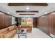 Cozy basement featuring comfortable seating, wood-paneled walls, and sliding glass doors to the backyard, perfect for entertaining at 11035 W Lakeshore Dr, Carmel, IN 46033
