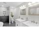 Modern bathroom featuring double sinks, stylish mirrors, and a spacious tiled shower for a spa-like experience at 11035 W Lakeshore Dr, Carmel, IN 46033