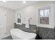 Elegant bathroom with a freestanding tub, natural light from two windows, and sleek fixtures for relaxation at 11035 W Lakeshore Dr, Carmel, IN 46033