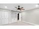 Bright bedroom with neutral carpet features ceiling fan, built-in bookshelves, closet, and interior door at 11035 W Lakeshore Dr, Carmel, IN 46033