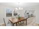 Bright dining area featuring modern lighting, large window, and adjacent kitchen at 11035 W Lakeshore Dr, Carmel, IN 46033