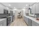 Spacious kitchen with gray cabinets, stainless steel appliances, and an adjacent dining area at 11035 W Lakeshore Dr, Carmel, IN 46033