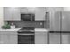 Modern kitchen featuring gray cabinets, stainless steel appliances, and sleek countertops at 11035 W Lakeshore Dr, Carmel, IN 46033