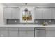 Modern kitchen featuring gray cabinets, stainless steel appliances, and a gold faucet at 11035 W Lakeshore Dr, Carmel, IN 46033
