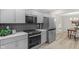 Updated kitchen featuring gray cabinets, stainless steel appliances, and a herringbone backsplash at 11035 W Lakeshore Dr, Carmel, IN 46033
