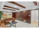 Cozy living room features wooden accent walls, beams, neutral carpet, and view of backyard through sliding glass door at 11035 W Lakeshore Dr, Carmel, IN 46033